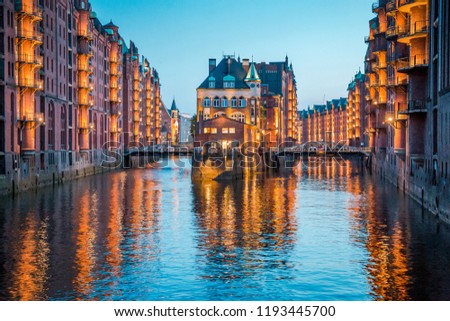 Classic view of famous Speicherstadt warehouse district, a UNESCO World Heritage Site since 2015, illuminated in beautiful post sunset twilight at dusk, Hamburg, Germany Royalty-Free Stock Photo #1193445700