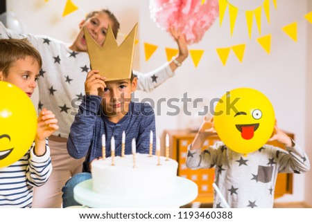 Little boy holding crown on his birthday party