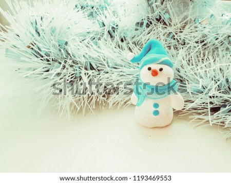 Plasticine Christmas composition with tinsel and plasticine snowman