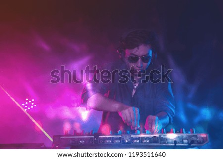 Nightclub DJ in Fun Party Concert on Stage with Color Lighting and Laser in Event Hall