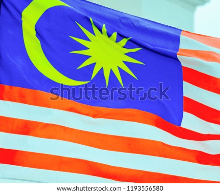 Malaysia flag waving on the blue sky in the wind with selective focus and crop fragment. Malaysia national flag concept