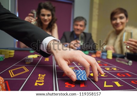 People sitting at the table while placing bets