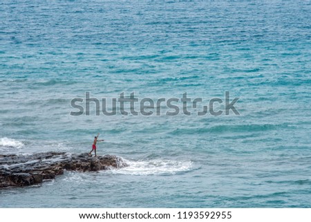 Boy fishing on rocks, Travel to Sao Tome and Principe. Beautiful paradise island in Gulf of Guinea. Former colony of Portugal. Royalty-Free Stock Photo #1193592955