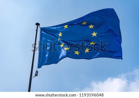 Flag of  European Union against blue sky .