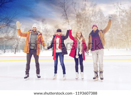 people, friendship and leisure concept - happy friends waving hands on skating rink outdoors