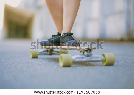 Awesome legs on the skateboard. Black sneakers. Skating inthe park