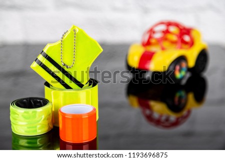 Pedestrian and children safety concept. Set of reflectors and blurred toy car on the background Royalty-Free Stock Photo #1193696875
