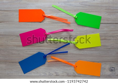Six Colorful Paperboard Tags on a Wooden Background