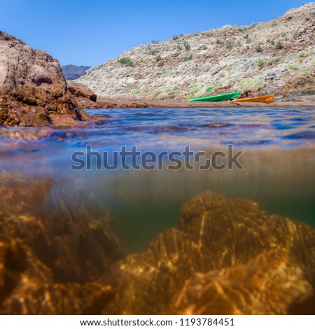 Underwater Split View Photo of a Nevada Lake, with Mountains and a Bright Blue Sky in the Background on a Sunny Day 