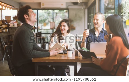 Group of friends chatting and using laptop in cafe at the coffee shop cafe in university talking and laughing together. Royalty-Free Stock Photo #1193788552