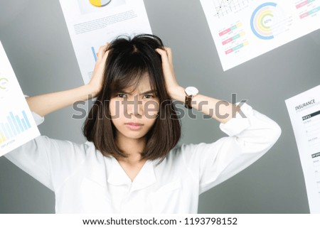 Business woman in a white dress is throw away a lot of paperwork and the documents are blown overhead. showing signs of stress from hard work. The concept of stress from hard work is bad for health.