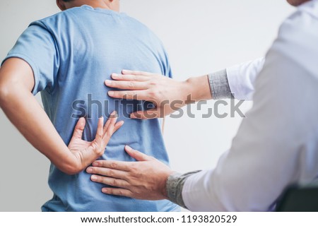 Doctor consulting with patient Back problems Physical therapy concept Royalty-Free Stock Photo #1193820529