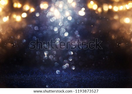 glitter vintage lights background. black, gold and blue. de-focused