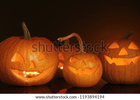 Halloween pumpkin heads. Glowing jack lanterns on dark background