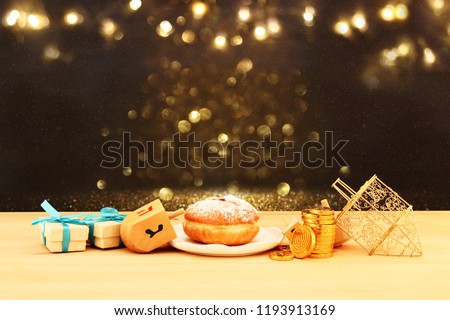 Image of jewish holiday Hanukkah with wooden dreidels (spinning top) and donut on the table