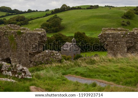 Ruins of a medieval castle in rural Ireland (Rock of Dunamase) with church in background