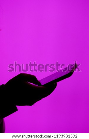 Hand holding smartphone on vivid  purple background