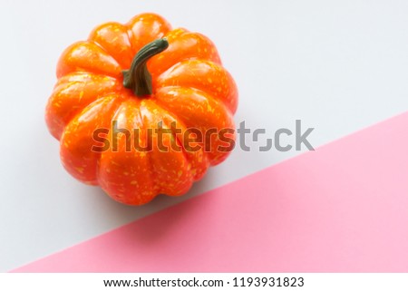 Decorative bright orange pumpkin on pastel colors geometric trendy background. Halloween and autumn concept. Autumn festival and sale background. Banner template. Space for text and advertising. 