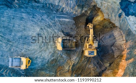 Quarry mining, work of the excavator and dump trucks, photo from the air Royalty-Free Stock Photo #1193990212