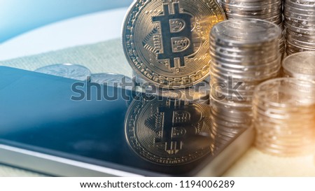 Smart phone and pile of stacked coins money and crypto bitcoins, Selective Focused. Financial and macro economics concept, top down angle shooting, macro photography.