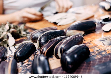 Eggplant cutting on wooden desk by unrecognizable woman.