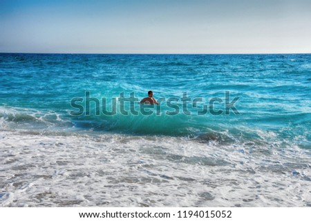 Man play with a waves. Mann in a sea with a big waves