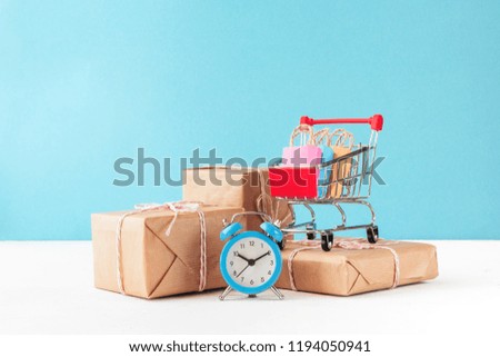 online shopping / e-commerce sale and delivery service concept: shopping cart multicolored packages and boxes with trolleybus logo on a blue background