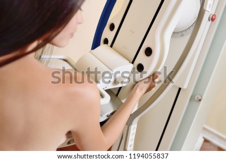 cute young girl on the examination of the breast using the mammography x ray machine, which carry out examination of the breast . Prevention of breast cancer