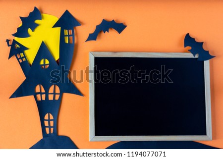 Halloween concept with haunted house castle and blackboard on orange background