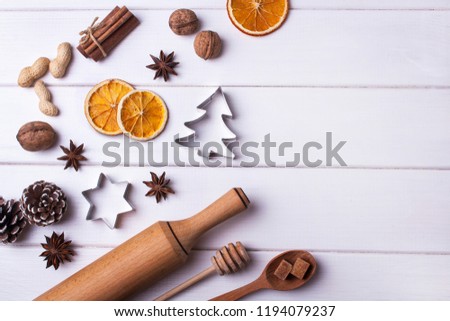 Cooking Christmas cookies. Nuts, cinnamon, pine cones and Christmas decorations on a white wooden background. View from above