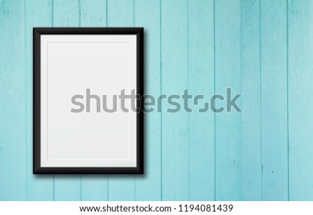 White poster Or a white picture frame hanging on the blue wood wall background in the room.Have space for your message.
