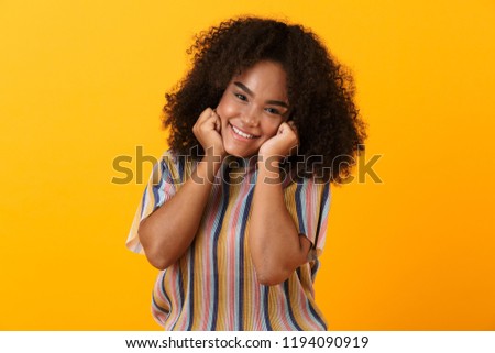 Image of happy young african cute girl posing isolated over yellow background.