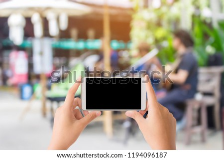woman use mobile phone and blurred image of buskers in the local market in Chiang mai ,Thailand