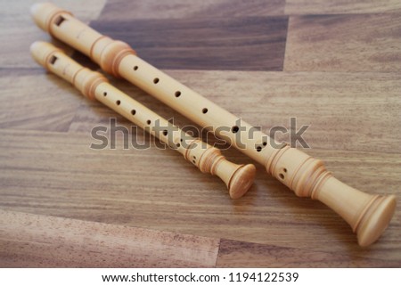 recorder, wooden flute on a wood table. Royalty-Free Stock Photo #1194122539