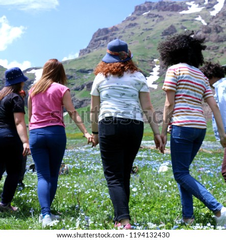 Young people dance Armenian folk dance in green beautiful field on the background of the highlands. Royalty-Free Stock Photo #1194132430