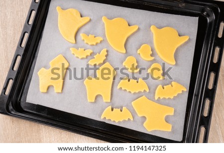 Fresh homemade decorating halloween cookies with ghost, creeping spider, bat, haunted castle and horrifying eyeball on wooden background, copy space