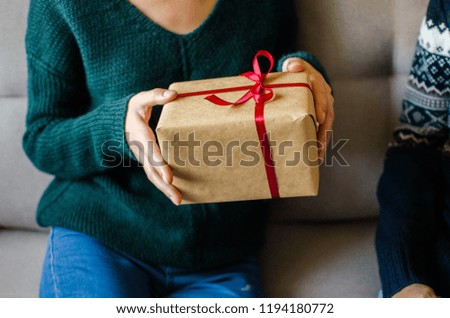 Woman in  sweater hold christmas or new year decorated gift box. Toned picture. Place for text
