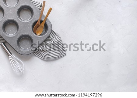 Kitchen utensils for baking - Cupcake metal mold, Whisk, wooden spoons on Crumpled Striped Napkin. Top view, Flat lay, Copy space. Minimal picture.