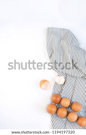 Pastry cooking minimal concept - raw uncooked eggs on Crumpled Striped Napkin, concrete white background. Top view, Flat lay, Copy space.