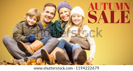 Portrait of happy family sitting on field at park against abstract yellow background
