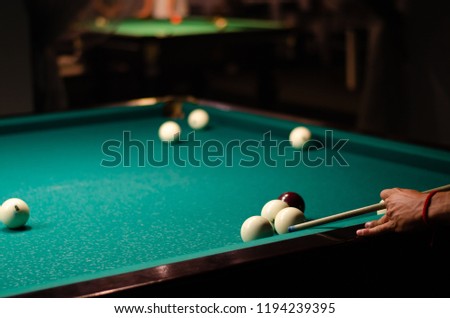Playing billiard. Billiards balls and cue on green billiards table. Russian pyramid.