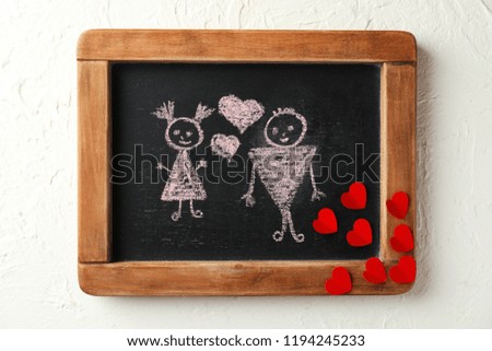 Drawn couple with hearts on small chalkboard