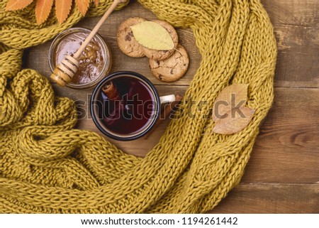 Mug or Cup of Hot Berry Tea With Yellow Warm Knitted Scarf Autumn Maple Leaves Wooden Background Top View Flat Lay Autumn Cold seaso
