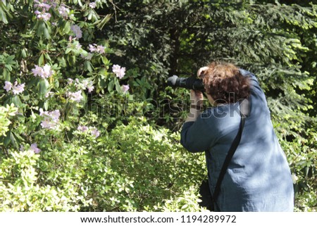 girl photographs flower. photographer
