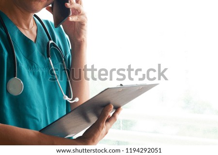Close-up of doctor/physician with black stethoscope using cell phone to call. medical concept Royalty-Free Stock Photo #1194292051
