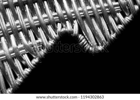 Black and white close up picture of silver painted wicker pattern, selective focus, space for text.