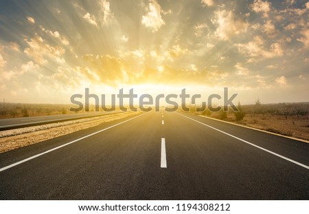 dramatic sunrise on asphalt road Royalty-Free Stock Photo #1194308212