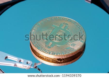 Bitcoin digital decentralised peer to peer on a hard disk surface. Selective focus to the coin
