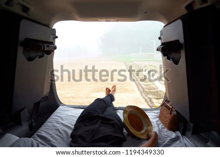 Women relaxing in car trunk and watching fog and nature view , Road trip , Travel concept. 