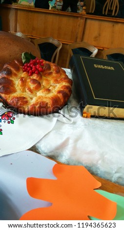 on the table is a black-bound Bible and fresh, ruddy bread